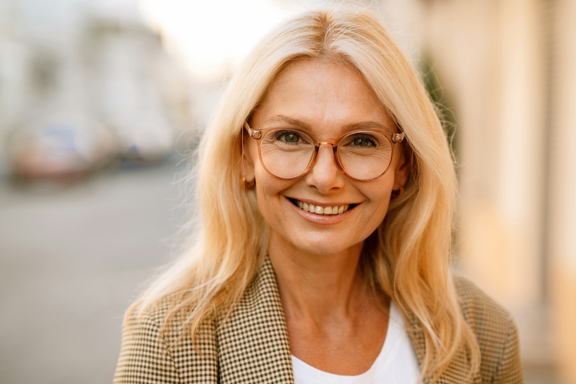 Mature white woman wearing eyeglasses smiling and looking at camera